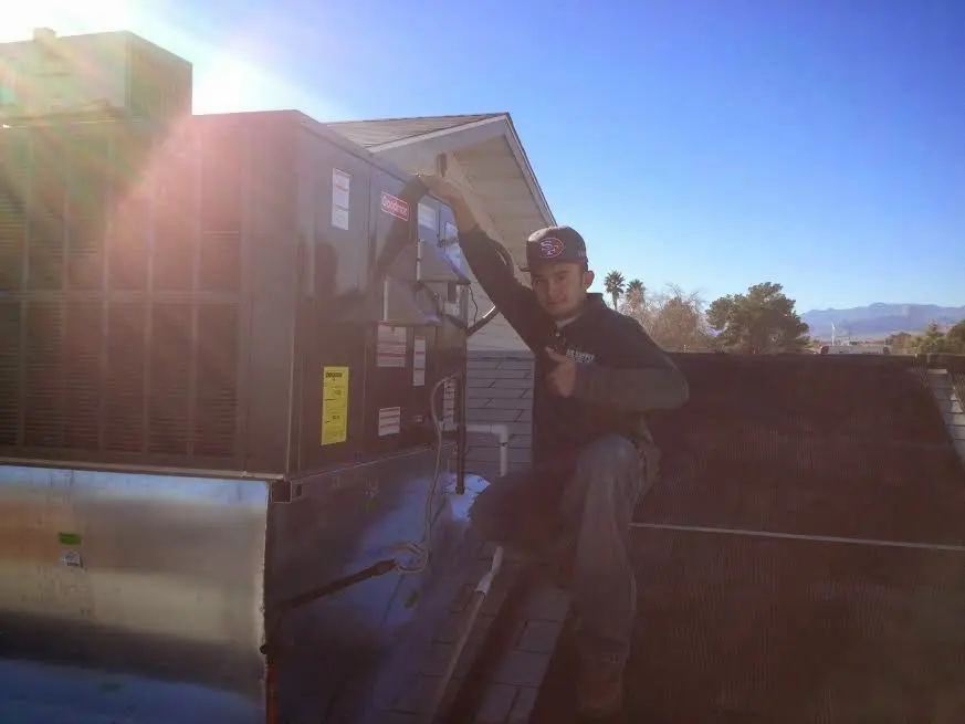 HVAC technician performing AC Tune-Up on a rooftop unit in Des Plaines